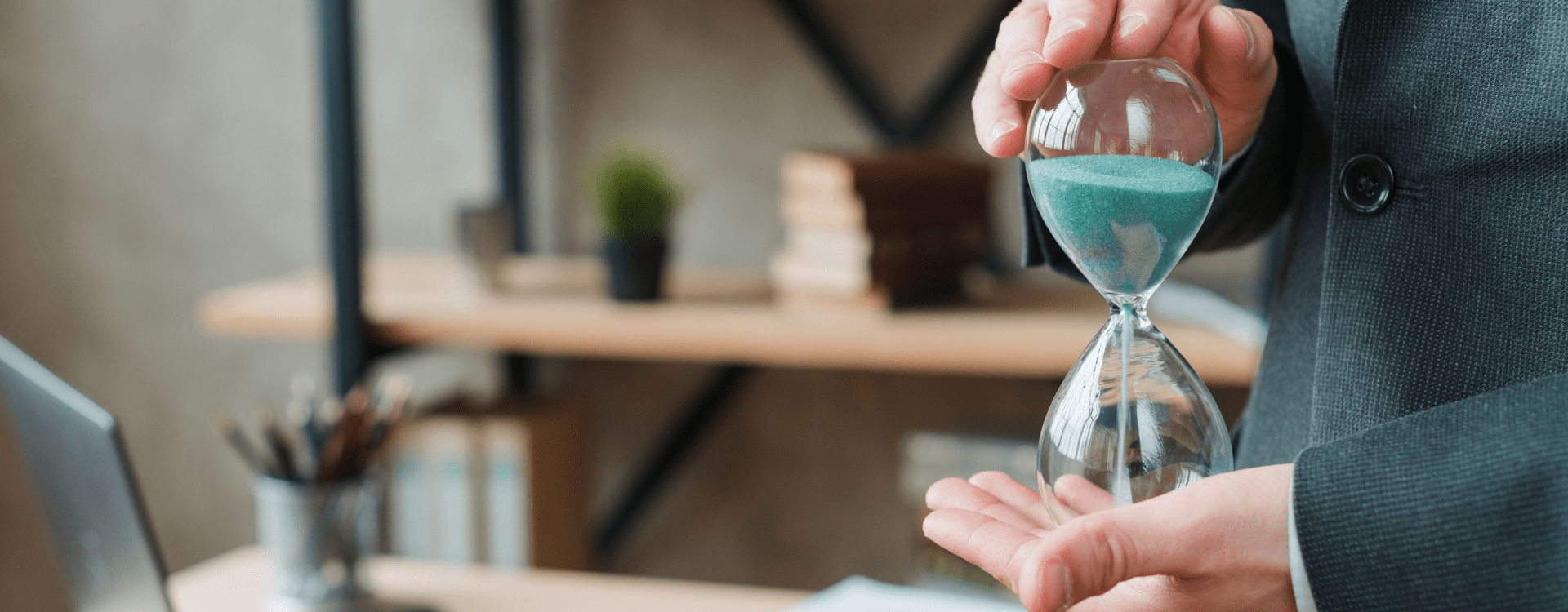 Pessoa num escritório a segurar uma ampulheta