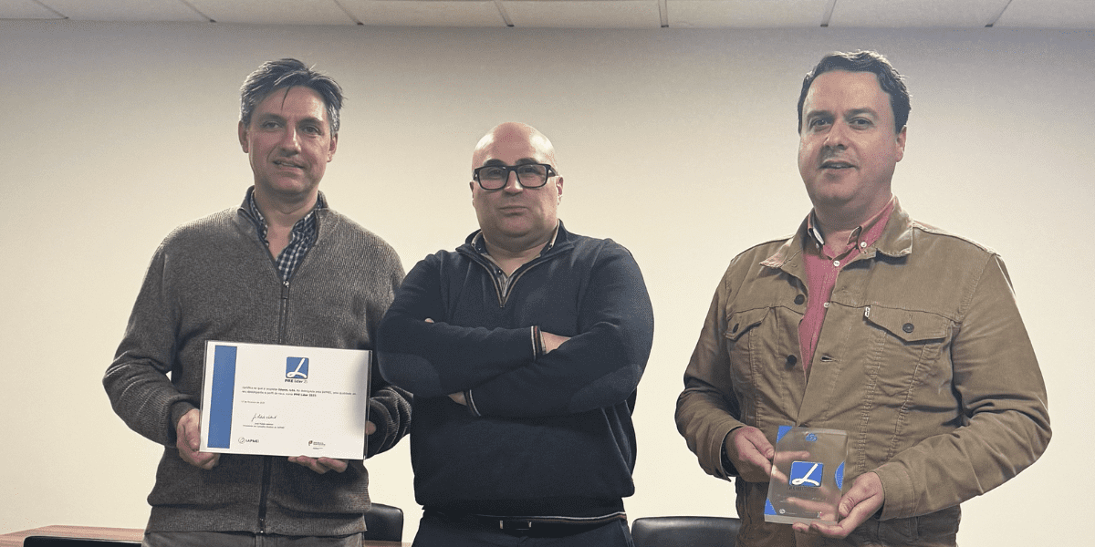 Três homens a posar para foto, dois com um prémio na mão